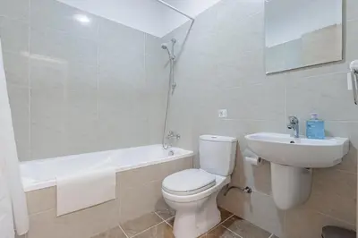 a bathroom with a toilet and a sink and a bath tub at Stylish One-Bedroom Sea Retreat in Paralimni