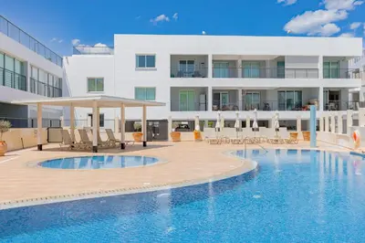 a swimming pool in front of a building at Stylish One-Bedroom Sea Retreat in Paralimni
