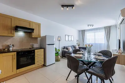 a kitchen and dining room with a table and chairs at Stylish One-Bedroom Sea Retreat in Paralimni
