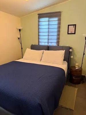 a blue bed in a room with a window at Safari House with fireplace in Agros