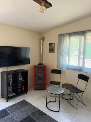 a living room with two chairs and a flat screen tv at Safari House with fireplace in Agros