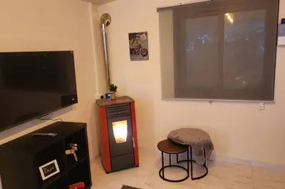 a living room with a flat screen tv and a stool at Safari House with fireplace in Agros