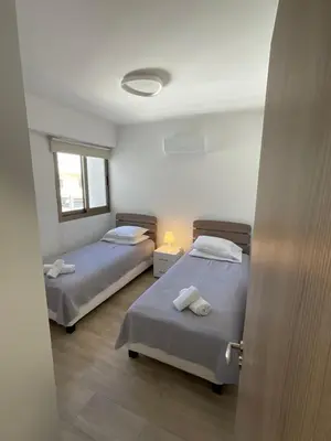 a room with two beds and a window at Le Voyageur II in Larnaka