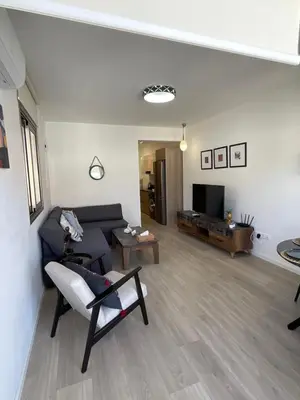 a living room with a couch and a tv at Le Voyageur II in Larnaka