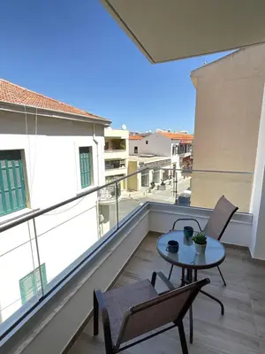 a balcony with a table and chairs and a view at Le Voyageur II in Larnaka