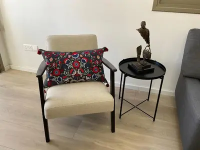 a chair with a pillow next to a table at Le Voyageur II in Larnaka