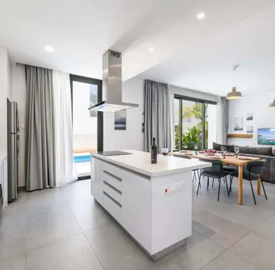 a kitchen and living room with a table and a dining room at By the beach Villa 2 in Protaras