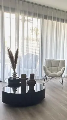 a living room with a chair and a coffee table at Sunset Gardens - Holiday Apartments in Limassol
