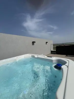 a hot tub in a room with blue water at Sunset Gardens - Holiday Apartments in Limassol