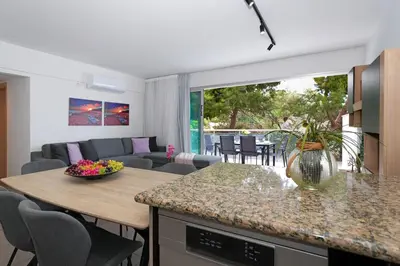 a kitchen and living room with a table and a couch at Alessia 2bed Apartment - Coralli Beachfront Resort in Protaras