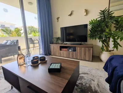 a living room with a tv and a coffee table at Violetta Apartment, Ground Floor Pool View in Paralimni