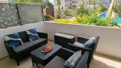 a balcony with a couch and a table and chairs at Violetta Apartment, Ground Floor Pool View in Paralimni
