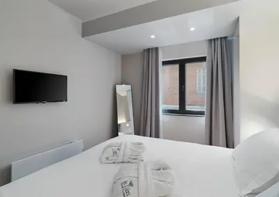 a white bedroom with a bed with towels on it at Le Vert Suites Platres in Platres