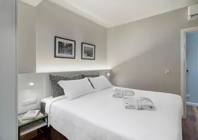 a white bed with two towels on top of it at Le Vert Suites Platres in Platres