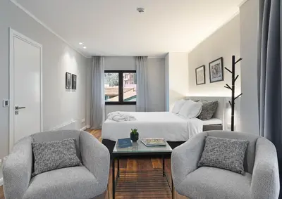 a bedroom with a bed and two chairs and a table at Le Vert Suites Platres in Platres