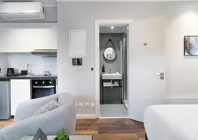 a living room with a chair and a kitchen at Le Vert Suites Platres in Platres