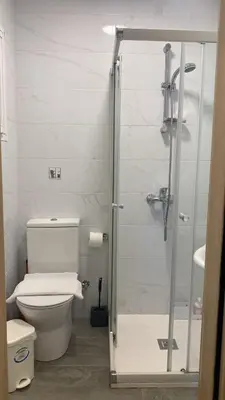 a bathroom with a toilet and a glass shower at Appartments 750m from beach, tourist area in Limassol
