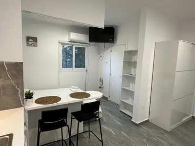 a small kitchen with a white counter and stools at Appartments 750m from beach, tourist area in Limassol