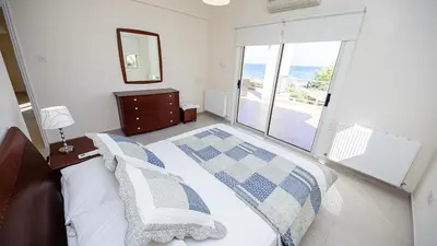 a bedroom with a bed with a view of the ocean at Protaras Holiday Villa 196 in Protaras