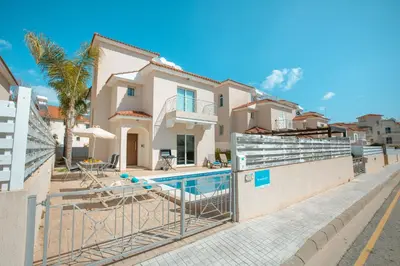 a villa with a swimming pool in front of a house at Pernera Holiday Villa 173 in Protaras