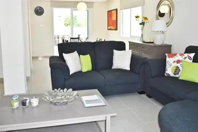 a living room with a blue couch and a table at Pernera Holiday Villa 173 in Protaras