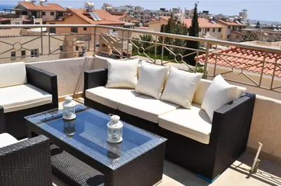 a patio with two couches and a table on a balcony at Pernera Holiday Villa 173 in Protaras