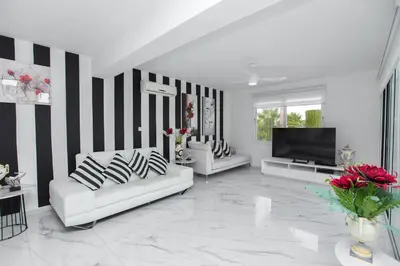 a living room with two white couches and a flat screen tv at Protaras Holiday Villa 113 in Protaras