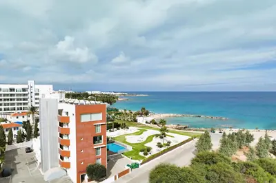an aerial view of a building and the ocean at Jenny - Beachfront Apartment in Protaras