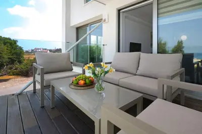 a living room with a couch and a table at Jenny - Beachfront Apartment in Protaras