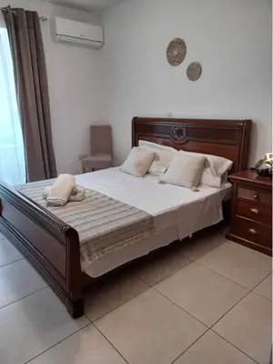a bedroom with a bed with white sheets and pillows at A+A Apartment in Kiti