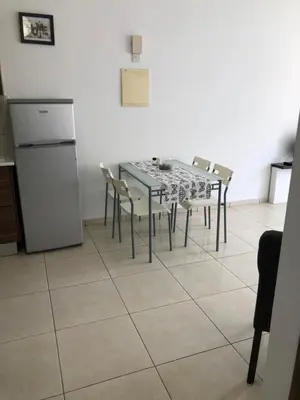 a kitchen with a table and chairs and a refrigerator at A+A Apartment in Kiti