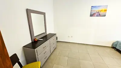 a bedroom with a dresser with a mirror on it at Heaven City Apartment, 150m from Chabad Lubavitch in Larnaka