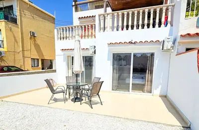 a patio with a table and chairs and a balcony at Beach Love BeachFront Apartment in Pyla