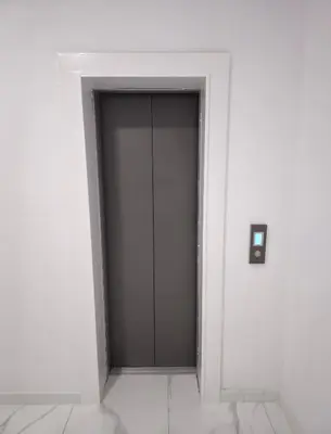 a gray door in a white room with a wall at The Heart of the City in Limassol