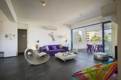 a living room with a purple couch and a table at Protaras Aster Seaside Suite in Protaras