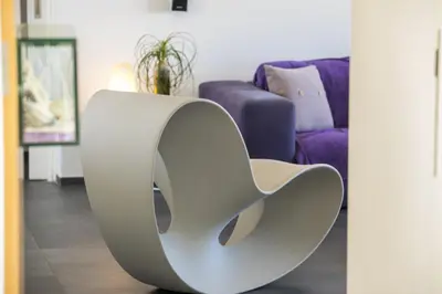 a white chair in front of a living room at Protaras Aster Seaside Suite in Protaras