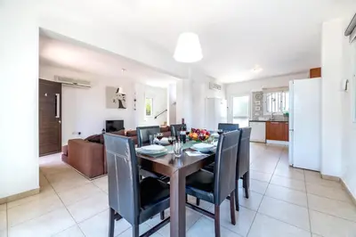 a dining room and living room with a table and chairs at Villa Amesta in Protaras