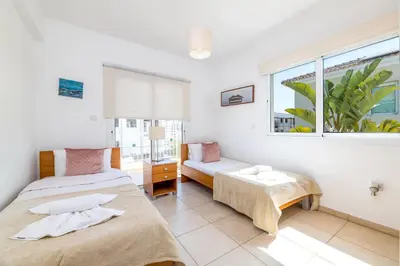 a bedroom with two beds and a window at Villa Amesta in Protaras