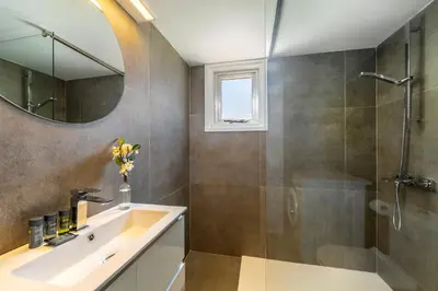 a bathroom with a sink and a shower and a mirror at Protaras O2 Seaside Suite in Protaras