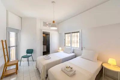 a bedroom with two beds and a desk and a chair at Protaras O2 Seaside Suite in Protaras