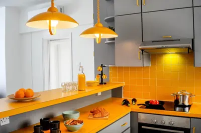 a kitchen with orange tile on the counters and lights at Protaras O2 Seaside Suite in Protaras