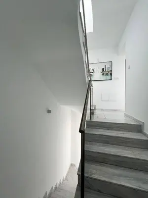 a staircase in a house with white walls and wooden floors at Hubstay - Seaview Villa Oriana in Larnaca in Larnaka