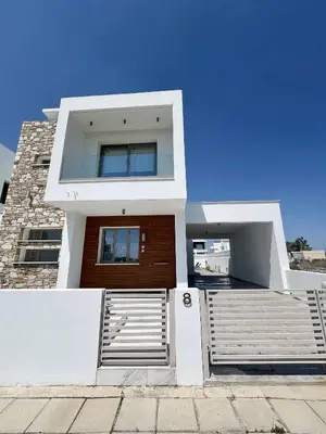 a white house with a brown door at Hubstay - Seaview Villa Oriana in Larnaca in Larnaka