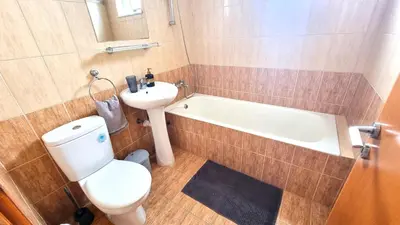 a bathroom with a toilet and a sink and a tub at Beach Haven: 7-Minute walk to the beach + Pool in Larnaka
