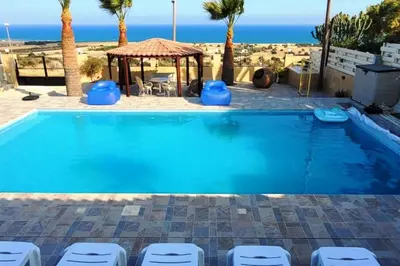 a swimming pool with chairs and a gazebo at Despol Villa in Alaminos
