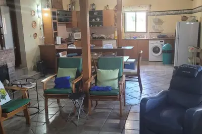 a living room with chairs and a table and a kitchen at Despol Villa in Alaminos