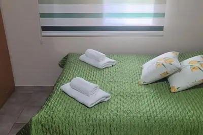a green bed with two towels and pillows on it at Despol Villa in Alaminos