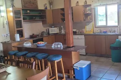 a kitchen with a bar with stools and a table at Despol Villa in Alaminos