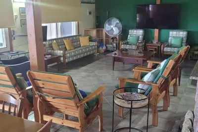 a living room filled with wooden chairs and tables at Despol Villa in Alaminos