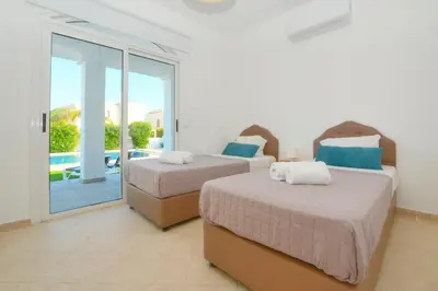 two beds in a room with a balcony at Villa Aquamarine in Ayia Napa
